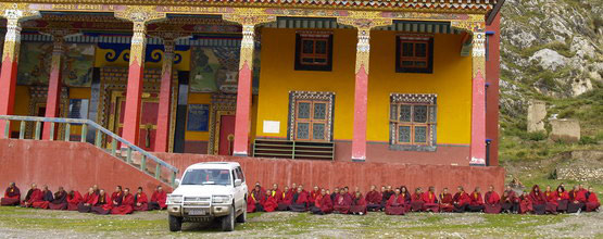 Mnisi z klasztoru Bencien w Tybecie recytują "Guru Jogę czterech pór dnia" dla zmarłej osoby, której ciało znajduje się w samochodzie.